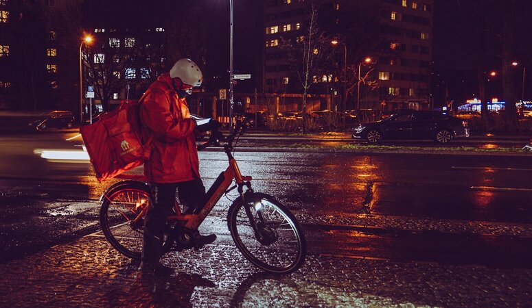 Lieferando-Fahrer mit E-Bike bei der Auslieferung.